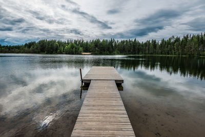 Wooden pier on lake against sky