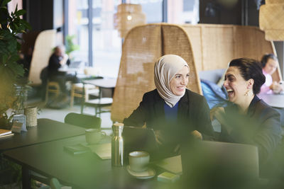 Businesswomen using digital tablet in cafe