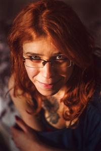 High angle portrait of young redhead woman wearing eyeglasses