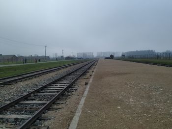 Railroad tracks on field against sky