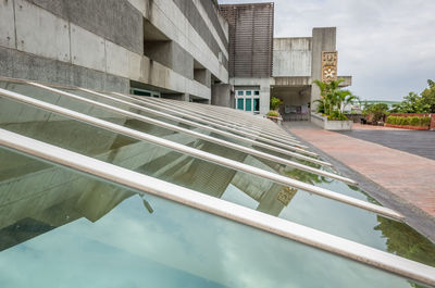 Reflection of building in swimming pool against sky