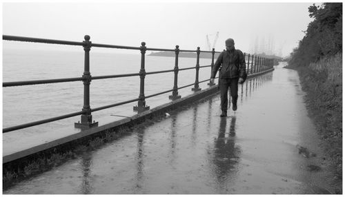 Rear view of people walking on railing