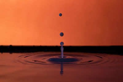 Three drops of milk on orange background