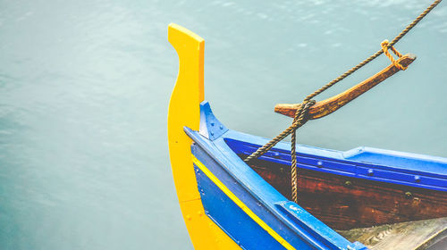 Close-up of yellow moored by sea against sky