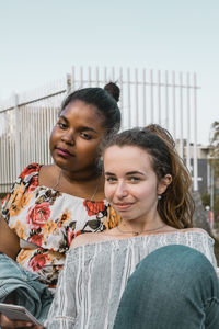 Portrait of smiling young woman against sky