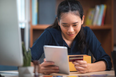 Man using mobile phone while sitting on table