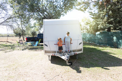 Two caucasian children play and spend alternative holidays in a caravan