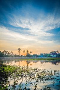 Scenic view of lake against sky at sunset