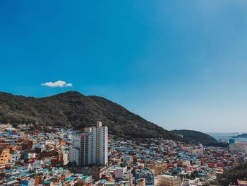 Aerial view of townscape against blue sky