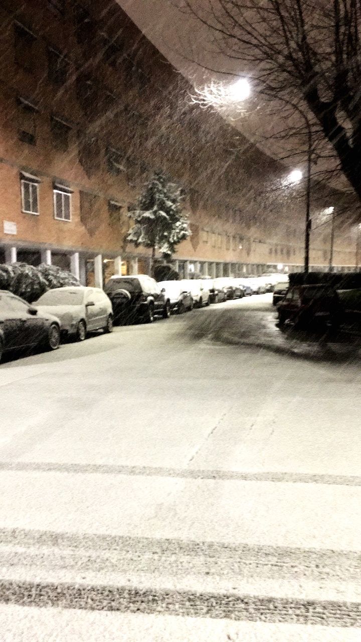 CARS ON STREET BY BUILDING DURING WINTER