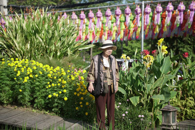 Rear view of woman standing amidst plants