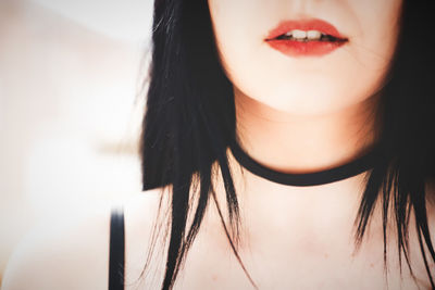Midsection of teenage girl with red lipstick