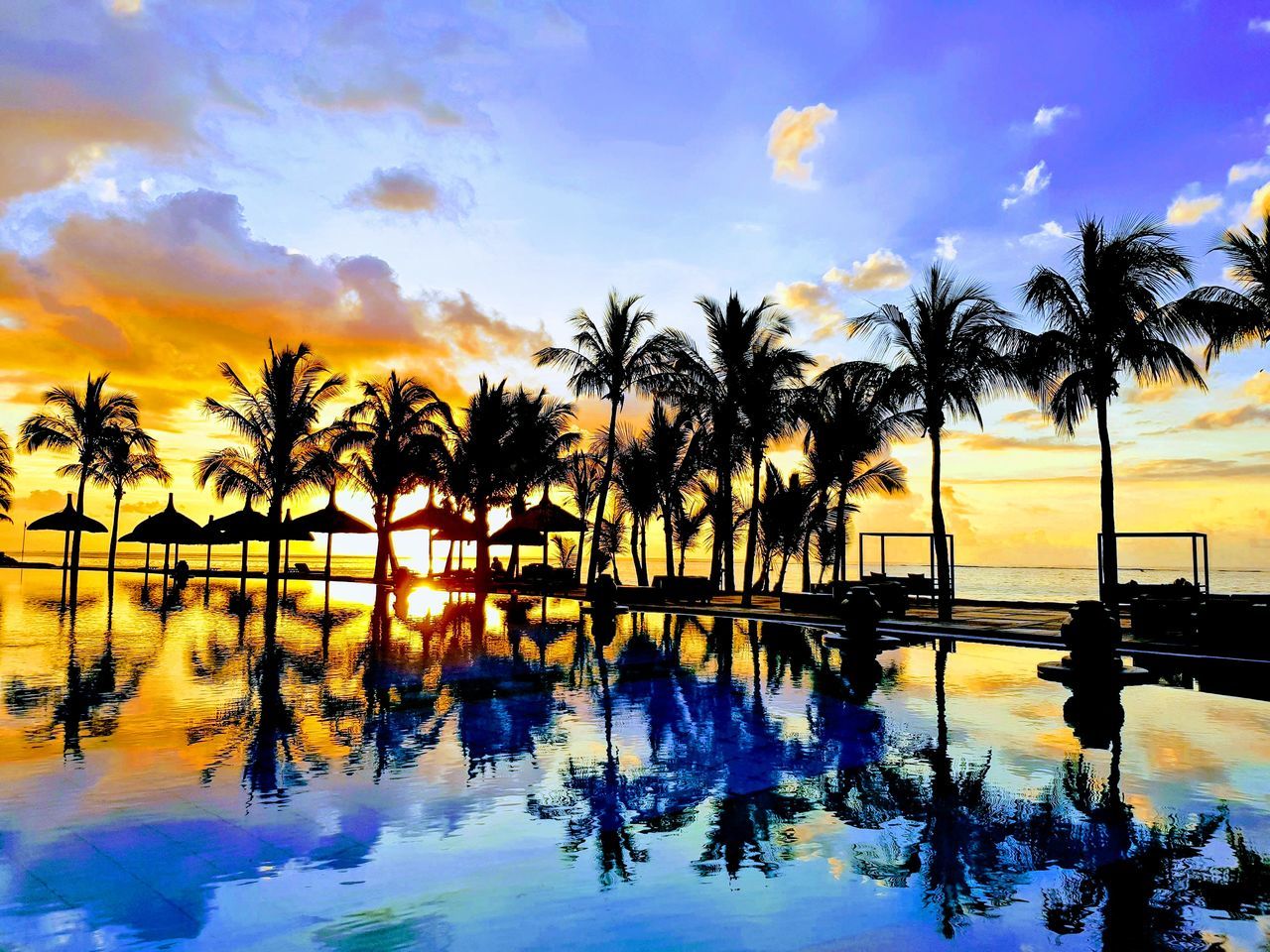 water, reflection, sunset, beauty in nature, swimming pool, tranquility, sky, silhouette, tranquil scene, nature, scenics, sea, tree, palm tree, cloud - sky, outdoors, beach, no people, horizon over water, day