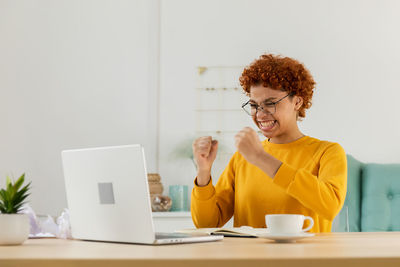 Businesswoman using laptop while sitting at desk in office