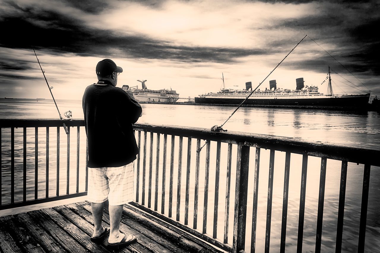 water, sky, sea, rear view, pier, standing, full length, cloud - sky, railing, lifestyles, men, leisure activity, cloud, nature, cloudy, casual clothing, fishing, tranquility