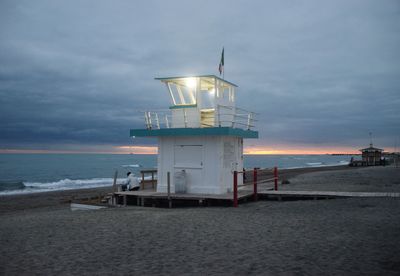 Lifeguard hut on beach against sky