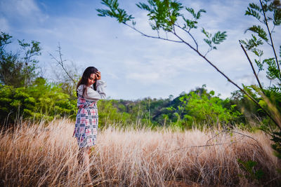 Woman standing on field against sky