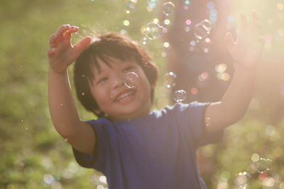 Close-up of smiling boy playing with bubbles