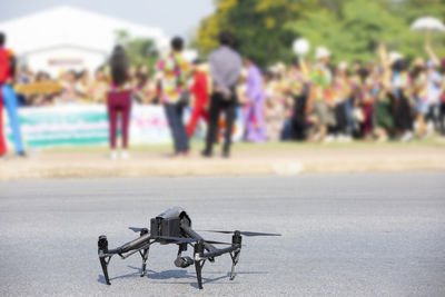 Drone on road with people in background