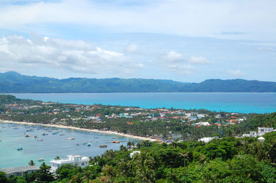 High angle view of townscape by sea against sky