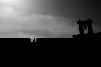 Low angle view of silhouette built structure against sky