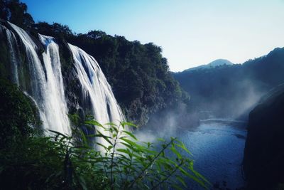 Scenic view of waterfall against sky