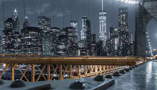 Illuminated bridge and buildings in city at night