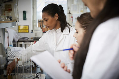 Female students with teacher studying in chemistry laboratory