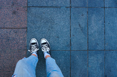 Low section of woman standing on footpath