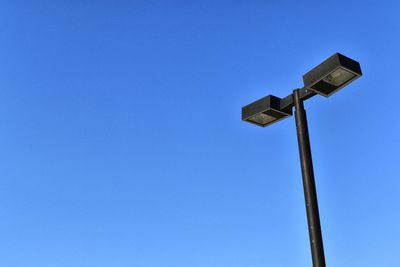 Low angle view of street light against blue sky