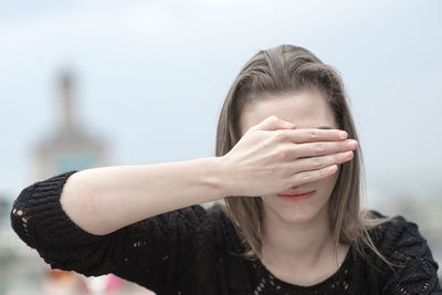 Woman covering eyes with hands