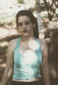 Portrait of young woman standing at park