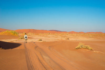 Woman in desert against clear blue sky