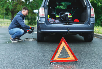 Low section of man skateboarding on road
