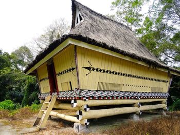 Wooden structure by house against sky