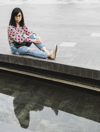 Woman sitting on swimming pool