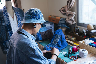 Man working over fabric on table
