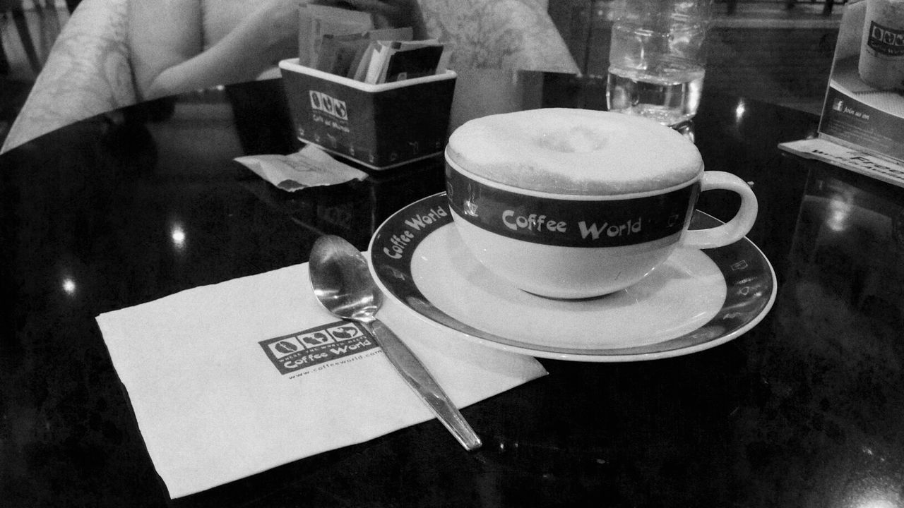 indoors, table, coffee cup, drink, food and drink, refreshment, still life, coffee - drink, saucer, communication, text, high angle view, freshness, cup, close-up, western script, coffee, no people, frothy drink, cafe