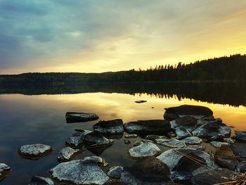 Scenic view of lake against sky at sunset