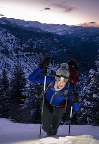 Woman backpacking during sunrise in mountains with headlamp