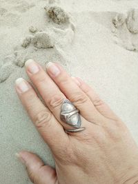 Close-up of hand on sand