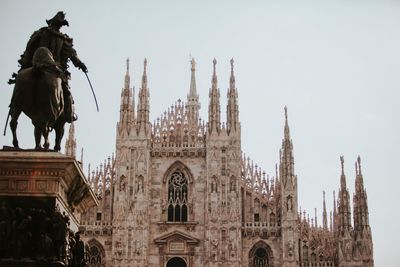 Low angle view of statue in city against clear sky