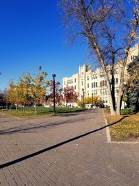 Street by buildings against clear blue sky
