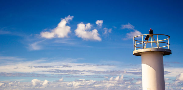 Low angle view of lighthouse against buildings and sky