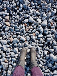 Low section of person standing on pebbles