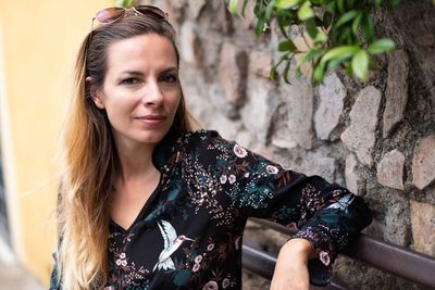 Portrait of woman sitting against wall