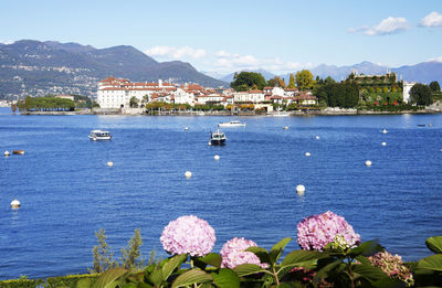 Scenic view of sea by townscape against sky