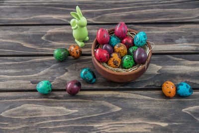 High angle view of easter eggs in bowl with bunny on table