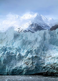 Glacier's blue ice on full display. mountain range in the background. 