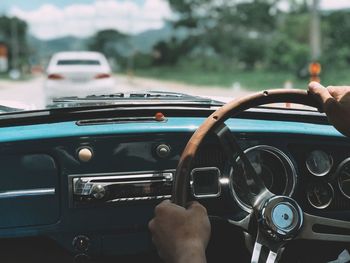 Cropped hands of man driving car